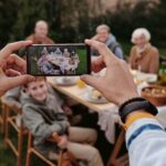 person taking photo using mobile phone to take family memories