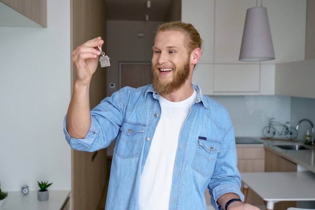 man purchase a new home and holding a home key